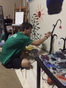 Artist Andrew painting his wall