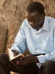 2011 - 07 Ugandan man reading Bible